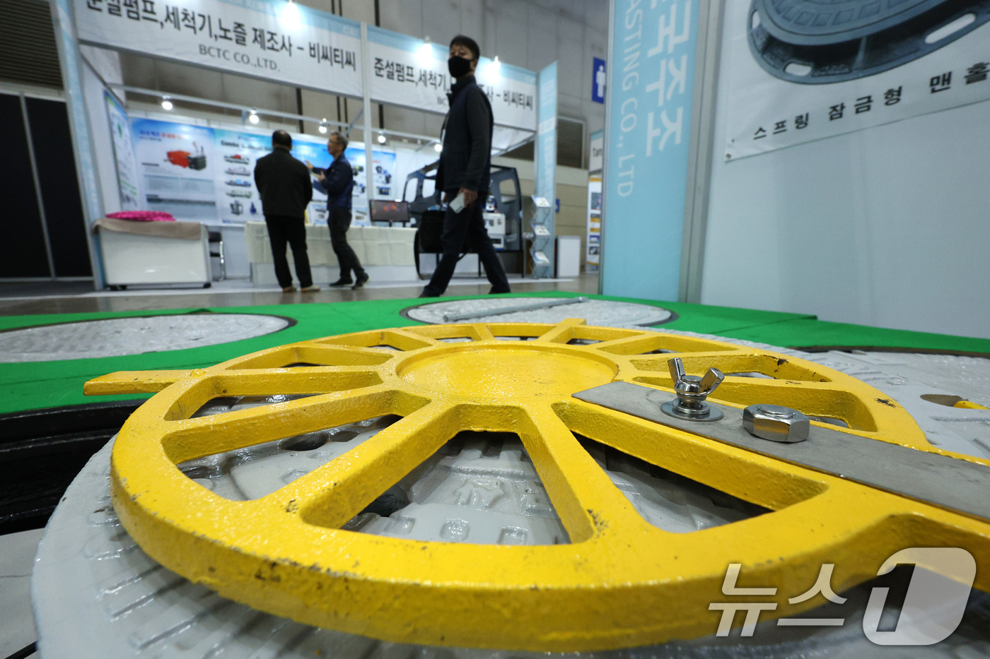 (고양=뉴스1) 신웅수 기자 = 19일 경기 고양시 킨텍스에서 열린 국제물산업박람회에서 관람객들이 스프링 잠금형 맨홀 뚜껑을 살펴보고 있다.오는 21일까지 열리는 이번 박람회는 물 …