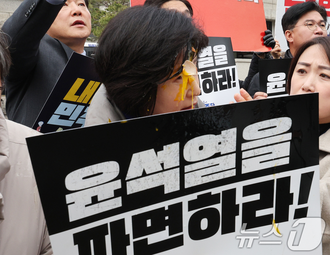 (서울=뉴스1) 신웅수 기자 = 백혜련 더불어민주당 의원이 20일 오전 서울 종로구 헌법재판소 앞에서 가진 윤석열 대통령 신속 파면 촉구 기자회견에서 계란을 얼굴에 맞고 있다. 2 …