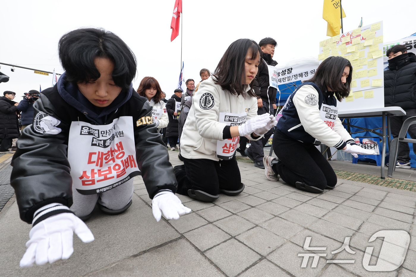 (서울=뉴스1) 신웅수 기자 = 윤석열 퇴진 전국 대학생 시국회의 회원들이 20일 서울 경복궁에서 윤석열 대통령의 탄핵 인용을 촉구하며 삼보일배를 하고 있다. 2025.3.20/뉴 …