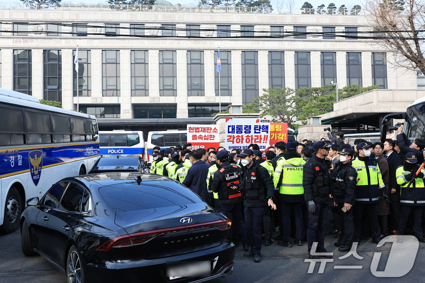 (서울=뉴스1) 박정호 기자 = 21일 오전 서울 종로구 재동 헌법재판소 앞에서 국민의힘과 더불어민주당의 기자회견이 이어지는 사이 차량이 들어가고 있다. 2025.3.21/뉴스1