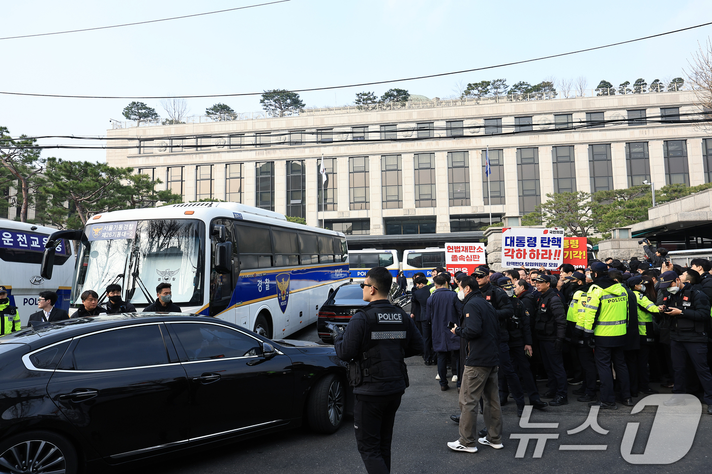 (서울=뉴스1) 박정호 기자 = 21일 오전 서울 종로구 재동 헌법재판소 앞에서 국민의힘과 더불어민주당의 기자회견이 이어지는 사이 차량이 들어가고 있다. 2025.3.21/뉴스1