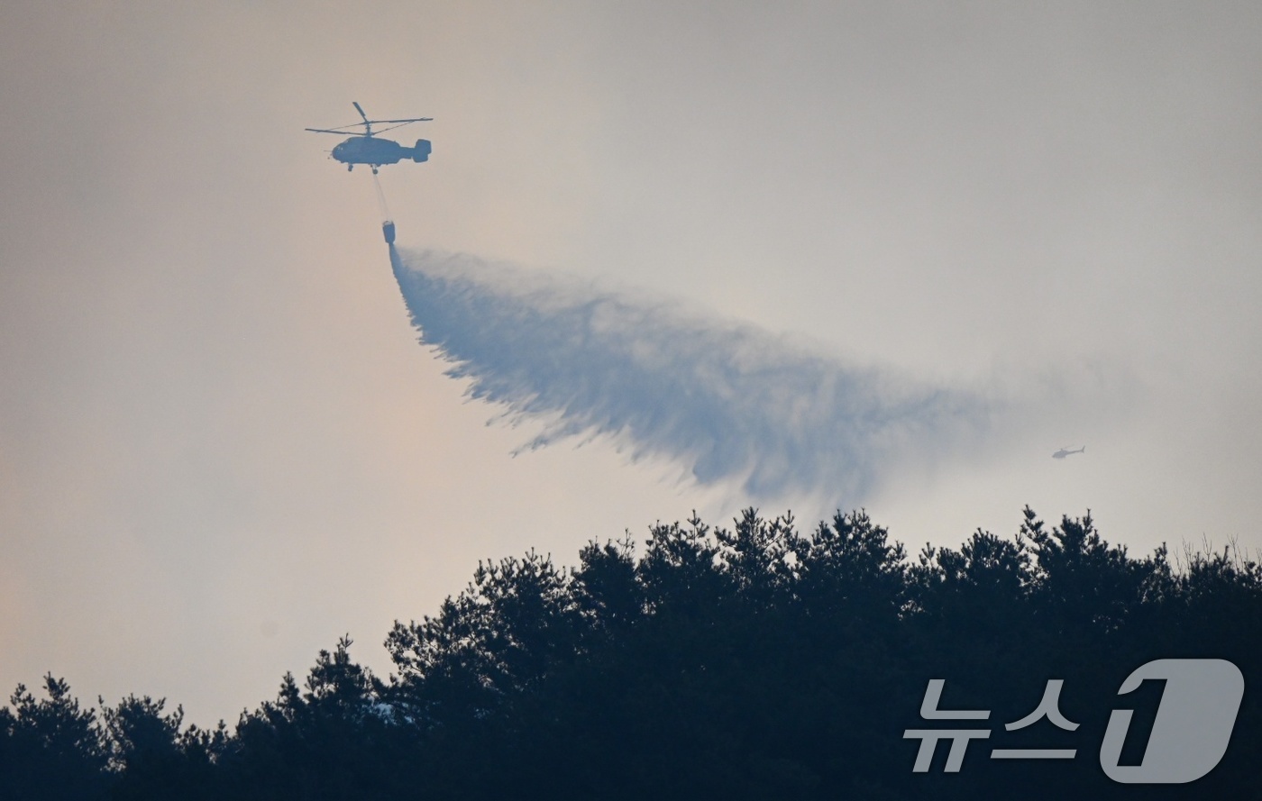 (산청=뉴스1) = 22일 경남 산청군 시천면 화재현장에서 일출과 동시에 소방당국이 헬기로 산불 진화 작업을 이어가고 있다.소방청과 산림청은 이날 가용 인원과 장비를 총 동원해 주 …