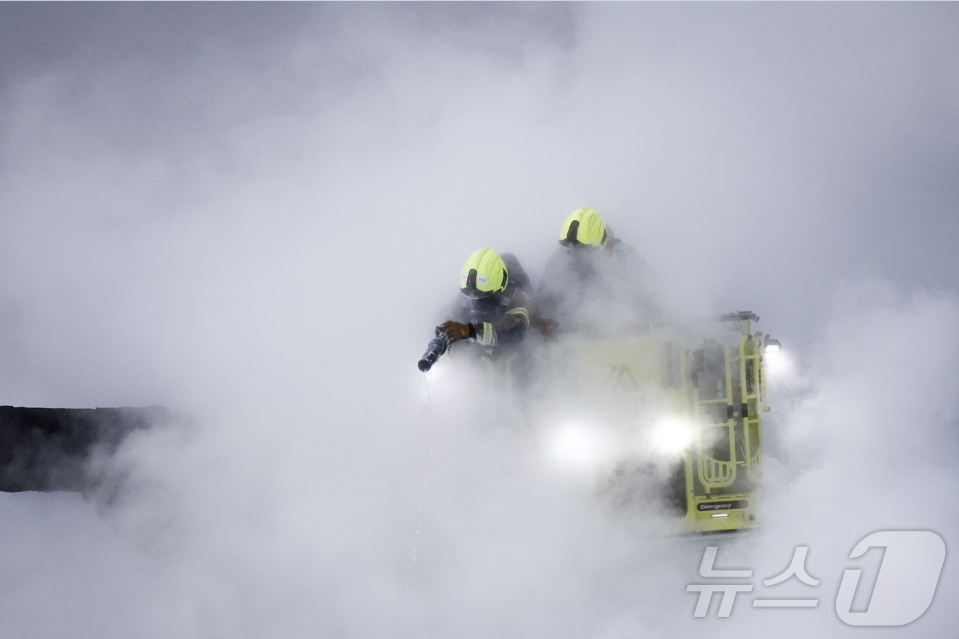 (런던 AFP=뉴스1) 우동명 기자 = 21일(현지시간) 영국 런던 히스로 공항 인근 변전소에서 화재가 발생해 연기가 솟아 오르는 현장서 소방대원이 진화를 하고 있다. 2025.0 …