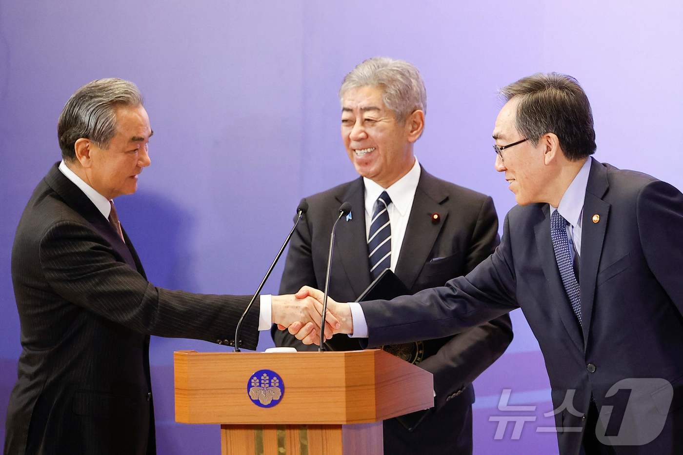 본문 이미지 - 조태열 외교 장관과 왕이 중국 외교부장, 이와야 다케시 일본 외무상이 22일(현지시간) 도쿄 외무성 이쿠라 공관에서 열린 한중일 외교장관 회의를 마친 뒤 기자회견 중 악수를 하고 있다. 2025.03,23 ⓒ AFP=뉴스1 ⓒ News1 우동명 기자