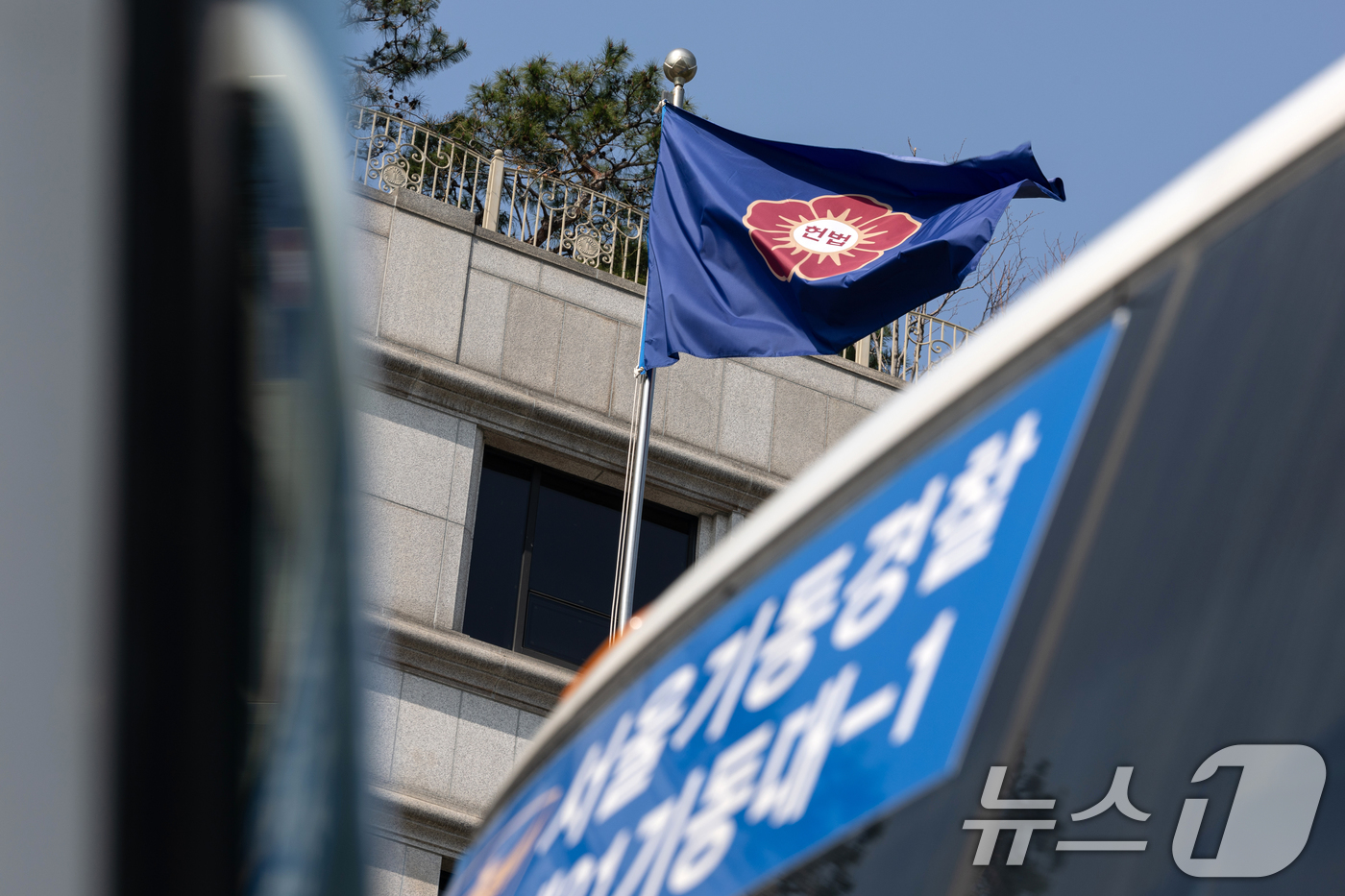 (서울=뉴스1) 이승배 기자 = '12·3 비상계엄' 관련 한덕수 국무총리의 탄핵 심판 사건 선고를 하루 앞둔 23일 서울 종로구 헌법재판소에서 경찰 차량 너머로 깃발이 바람에 휘 …