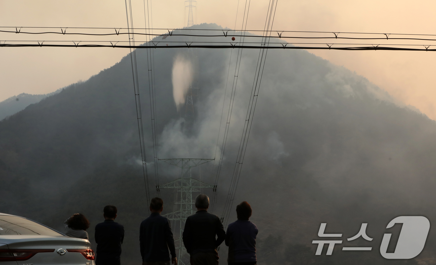 (산청=뉴스1) 윤일지 기자 = 경남 산청 대형 산불이 사흘째로 접어든 23일 오후 산청군 단성면 일대에서 주민들이 산불 연기가 치솟아오르는 모습을 지켜보고 있다.  2025.3. …