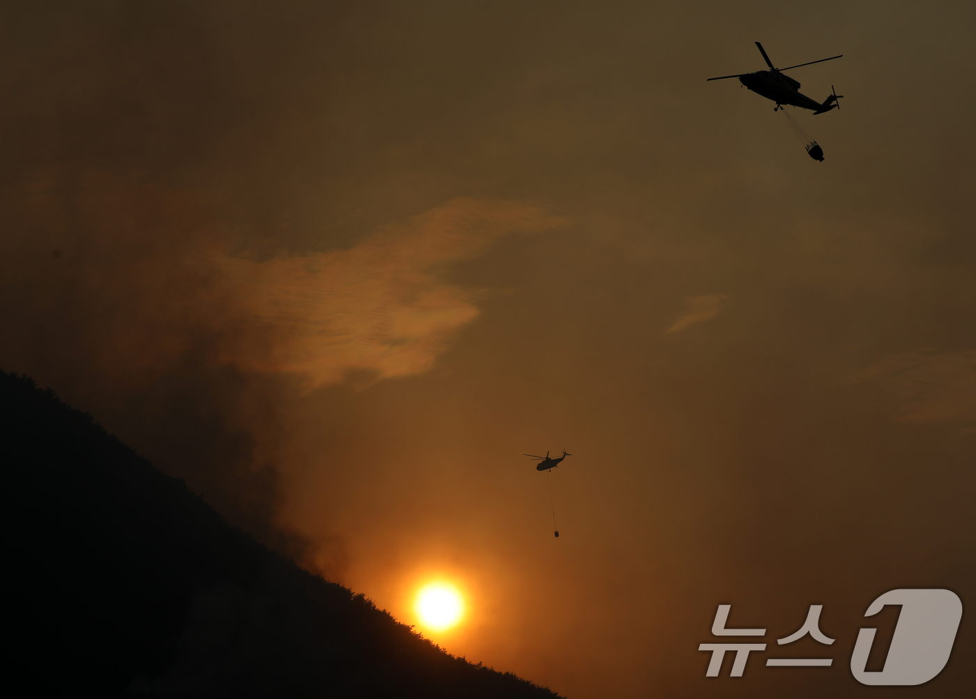 (산청=뉴스1) 윤일지 기자 = 경남 산청 대형 산불이 사흘째로 접어든 23일 오후 산청군 단성면 일대에서 산불진화 헬기가 진화작업을 벌이고 있다.  2025.3.23/뉴스1
