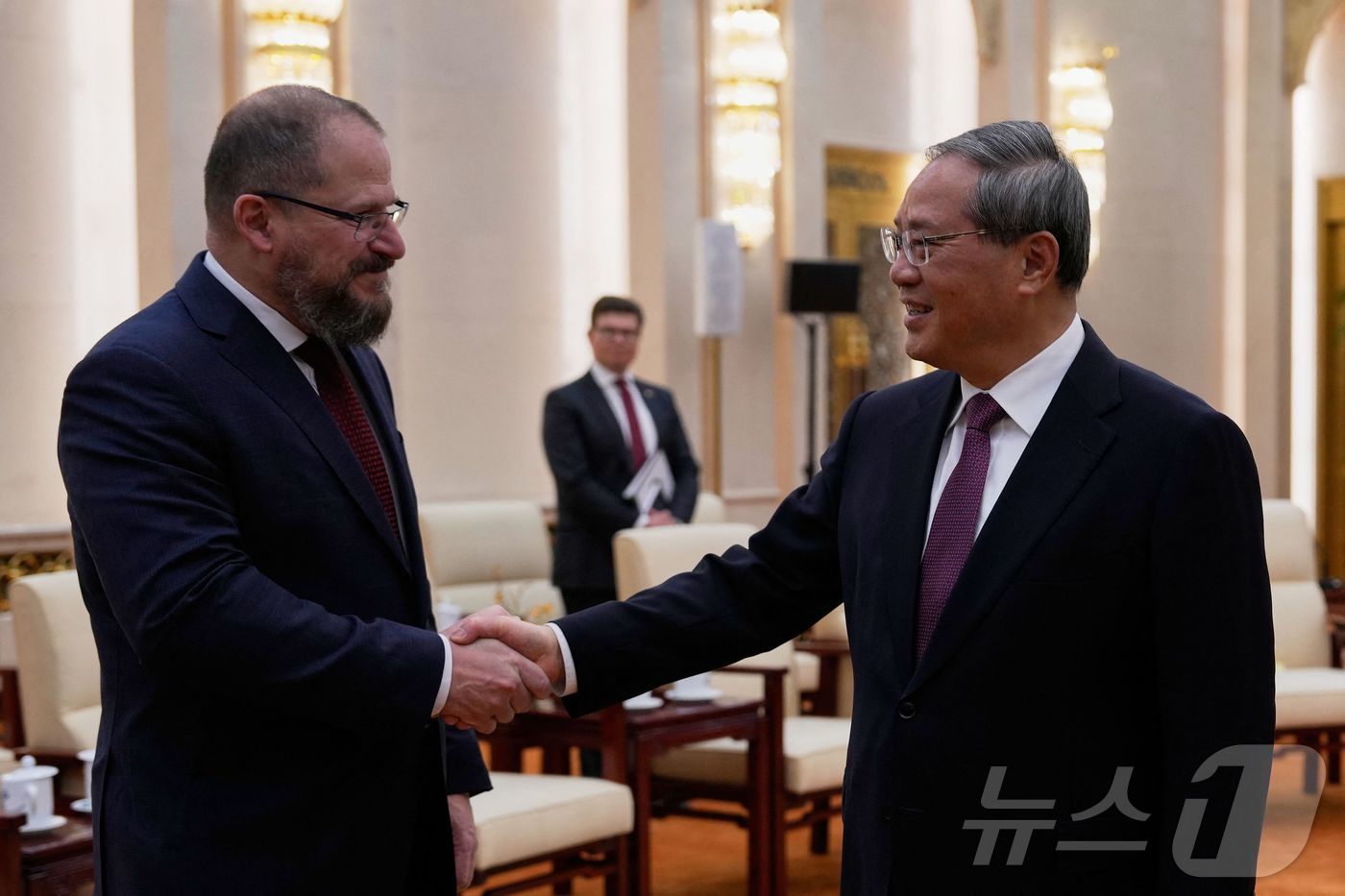 (베이징 AFP=뉴스1) 우동명 기자 = 리창 중국 총리가 23일(현지시간) 베이징 인민대회당에서 크리스티아노 아몬 퀄컴 회장과 만나 악수를 하고 있다. 2025.03.24ⓒ AF …