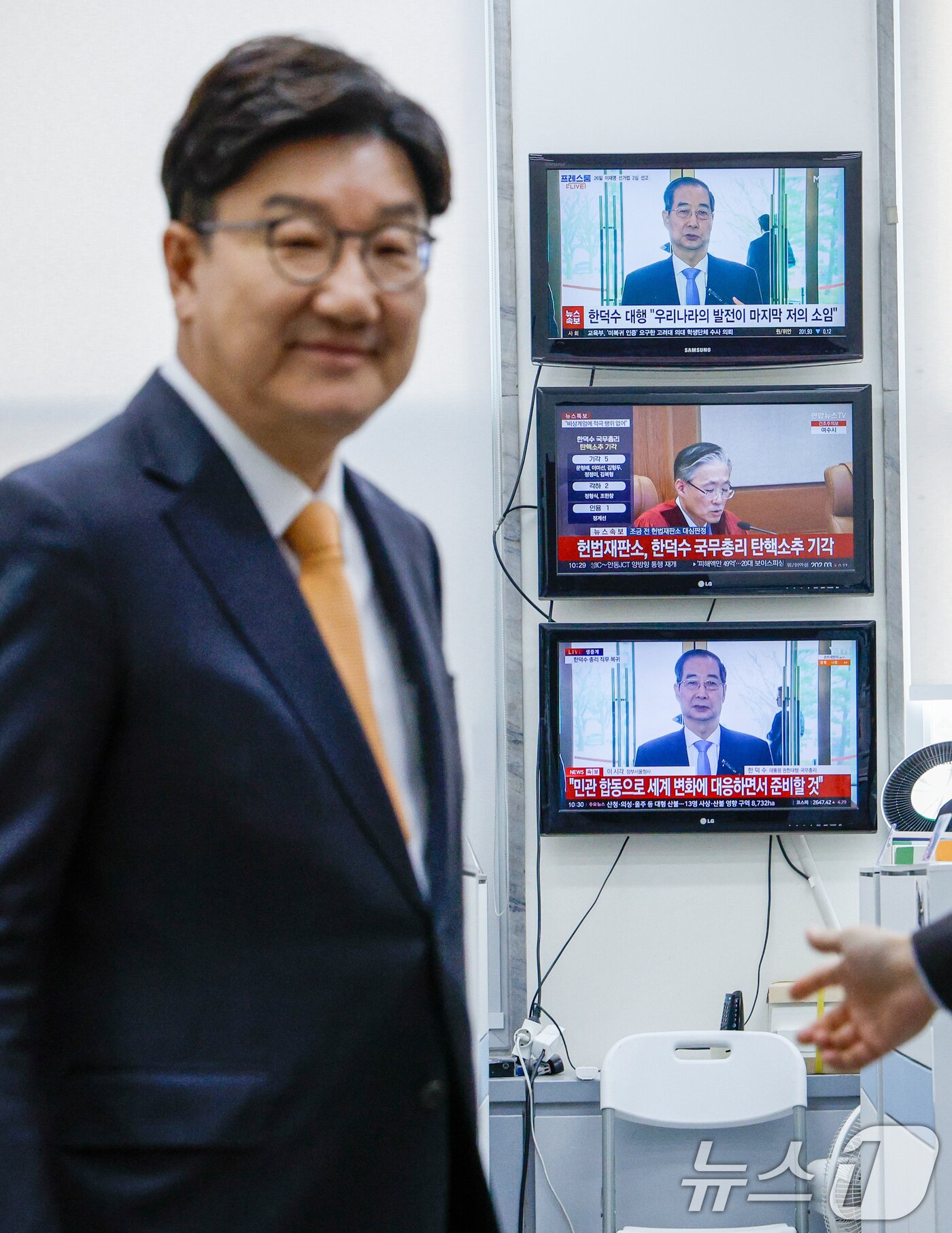 본문 이미지 - 권성동 국민의힘 원내대표가 24일 서울 여의도 국회에서 헌법재판소의 한덕수 국무총리 탄핵소추 기각 판결 관련 기자회견을 하기 위해 원내대표실에서 나오는 가운데 벽에 걸린 TV 화면에 한 총리의 직무복귀 입장발표 생중계 뉴스 화면이 나오고 있다. 2025.3.24/뉴스1 ⓒ News1 안은나 기자
