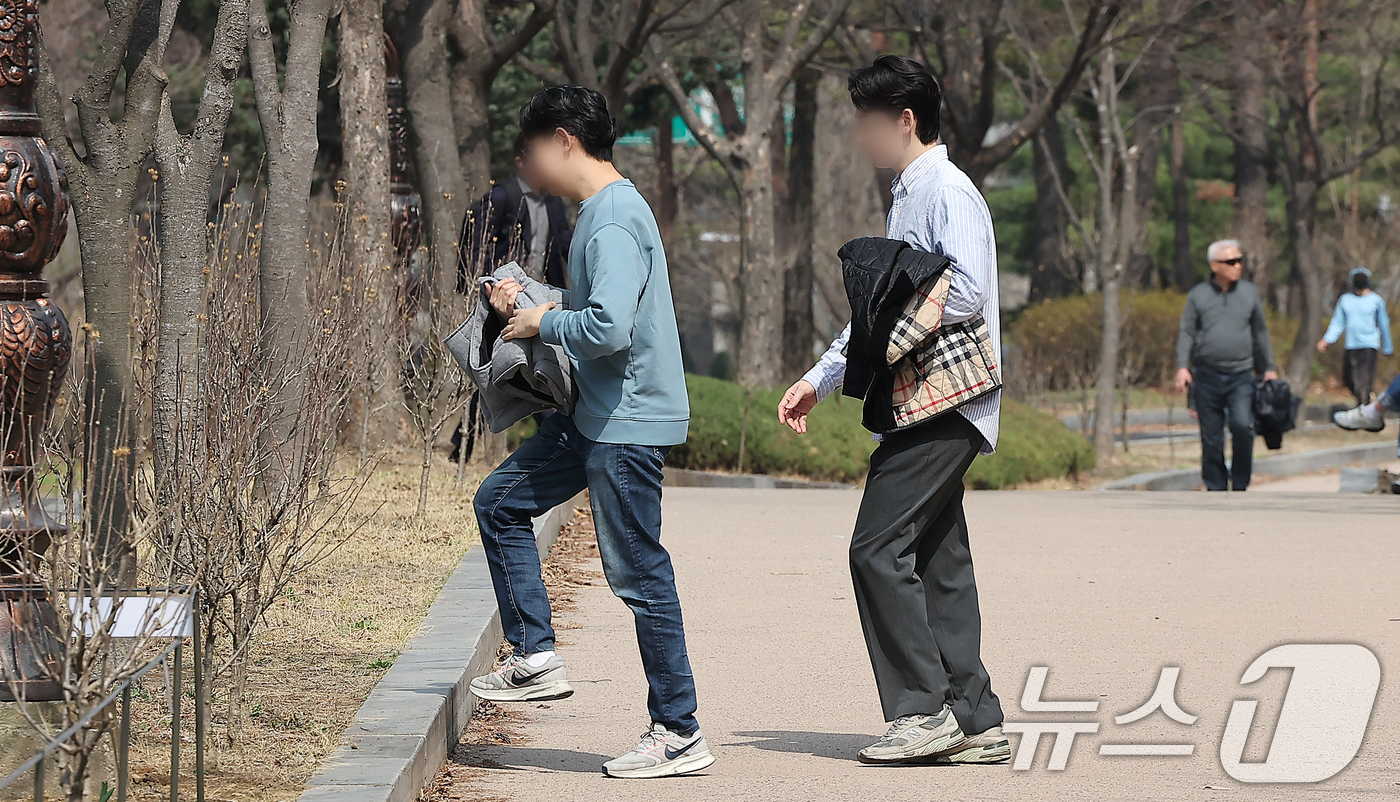 (서울=뉴스1) 김진환 기자 = 서울 지역 낮 최고기온이 21도까지 올라 완연한 봄날씨를 보인 24일 서울 영등포구 여의도공원에서 겉옷을 벗어 든 시민들이 산책을 하고 있다. 20 …