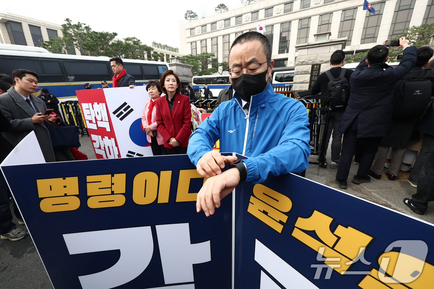 (서울=뉴스1) 김민지 기자 = 박홍배 더불어민주당 의원이 25일 오전 서울 종로구 헌법재판소 앞에서 윤석열 대통령 찬성 1인 시위를 하고 있다. 뒷편에서는 나경원, 조배숙 의원 …