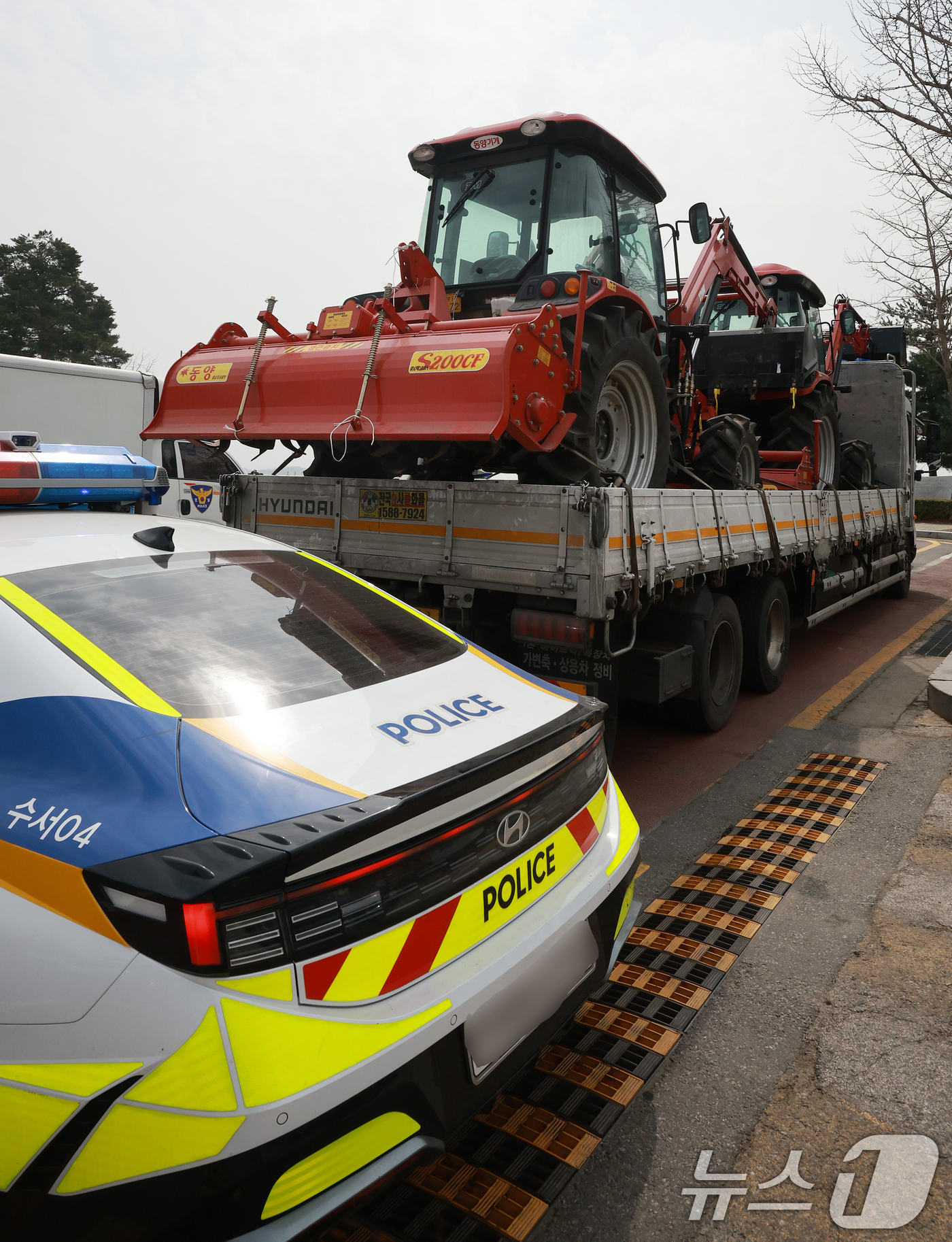 (서울=뉴스1) 김진환 기자 = 25일 서울 강남구 세곡동사거리에서 경찰 차량이 전국농민회총연맹(전농) 소속 트랙터의 진입을 막고 있다.전농은 이날 서울 서초구 남태령고개에서 윤석 …