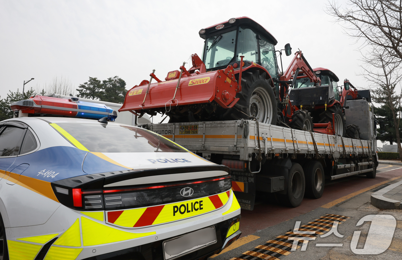 (서울=뉴스1) 김진환 기자 = 25일 서울 강남구 세곡동사거리에서 경찰 차량이 전국농민회총연맹(전농) 소속 트랙터의 진입을 막고 있다.전농은 이날 서울 서초구 남태령고개에서 윤석 …
