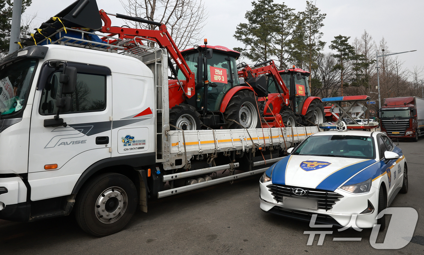 (서울=뉴스1) 김진환 기자 = 25일 서울 강남구 세곡동사거리에서 경찰 차량이 전국농민회총연맹(전농) 소속 트랙터의 진입을 막고 있다.전농은 이날 서울 서초구 남태령고개에서 윤석 …