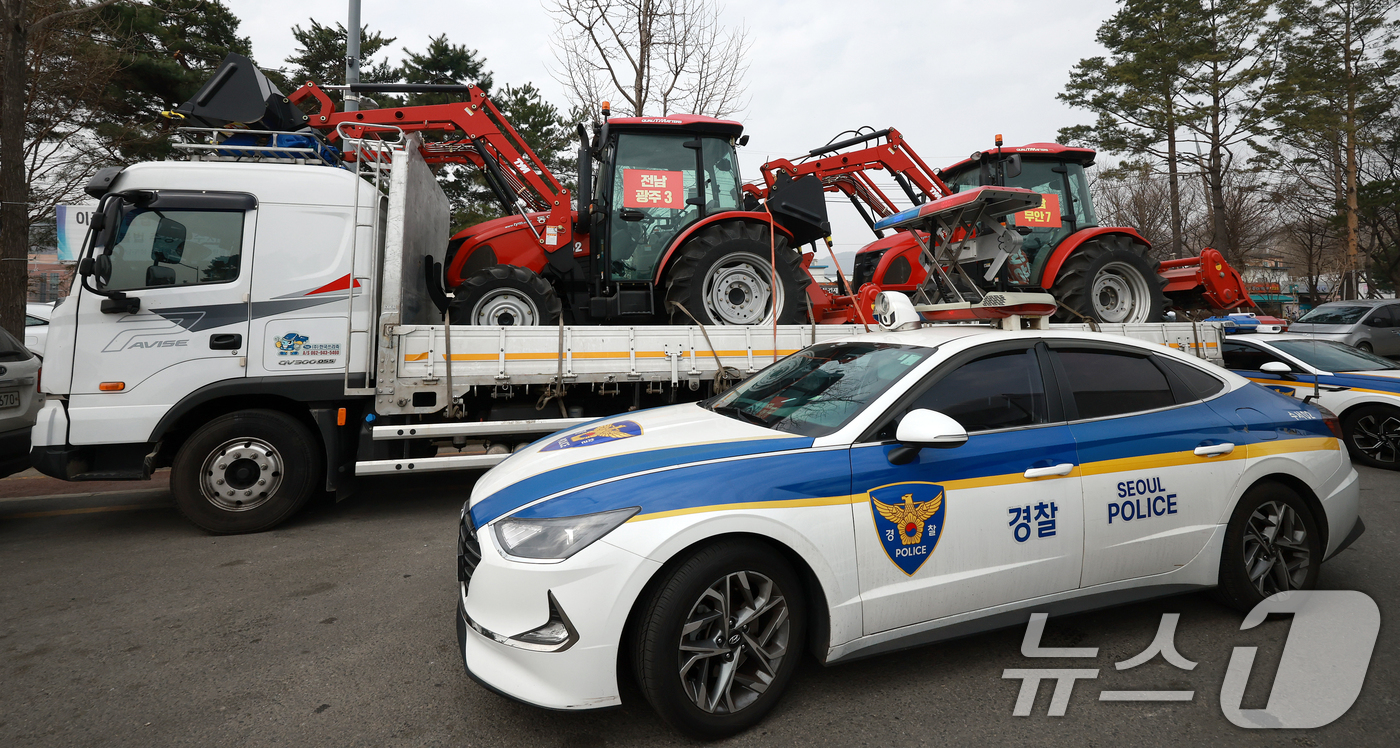 (서울=뉴스1) 김진환 기자 = 25일 서울 강남구 세곡동사거리에서 경찰 차량이 전국농민회총연맹(전농) 소속 트랙터의 진입을 막고 있다.전농은 이날 서울 서초구 남태령고개에서 윤석 …