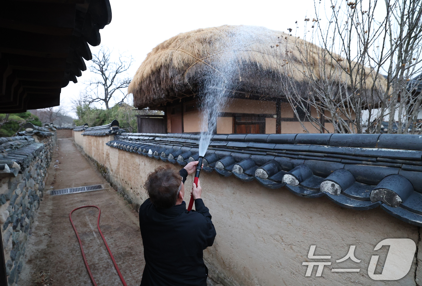 (안동=뉴스1) 김영운 기자 = 경북 의성군 산불이 나흘째 이어지고 있는 25일 오후 경북 안동시 하회마을에서 관계자들이 화재에 대비해 초가지붕에 물을 뿌리고 있다. 2025.3. …