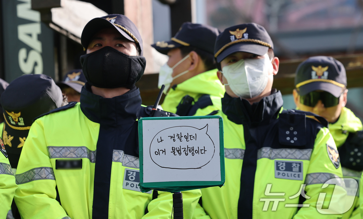 (서울=뉴스1) 김성진 기자 = 26일 오전 서울 종로구 광화문 서십자각 천막농성장 인근에서 전국농민회총연맹 트랙터 시위대와 대치하는 경찰 앞에 시위대가 적은 손팻말이 놓여져 있다 …
