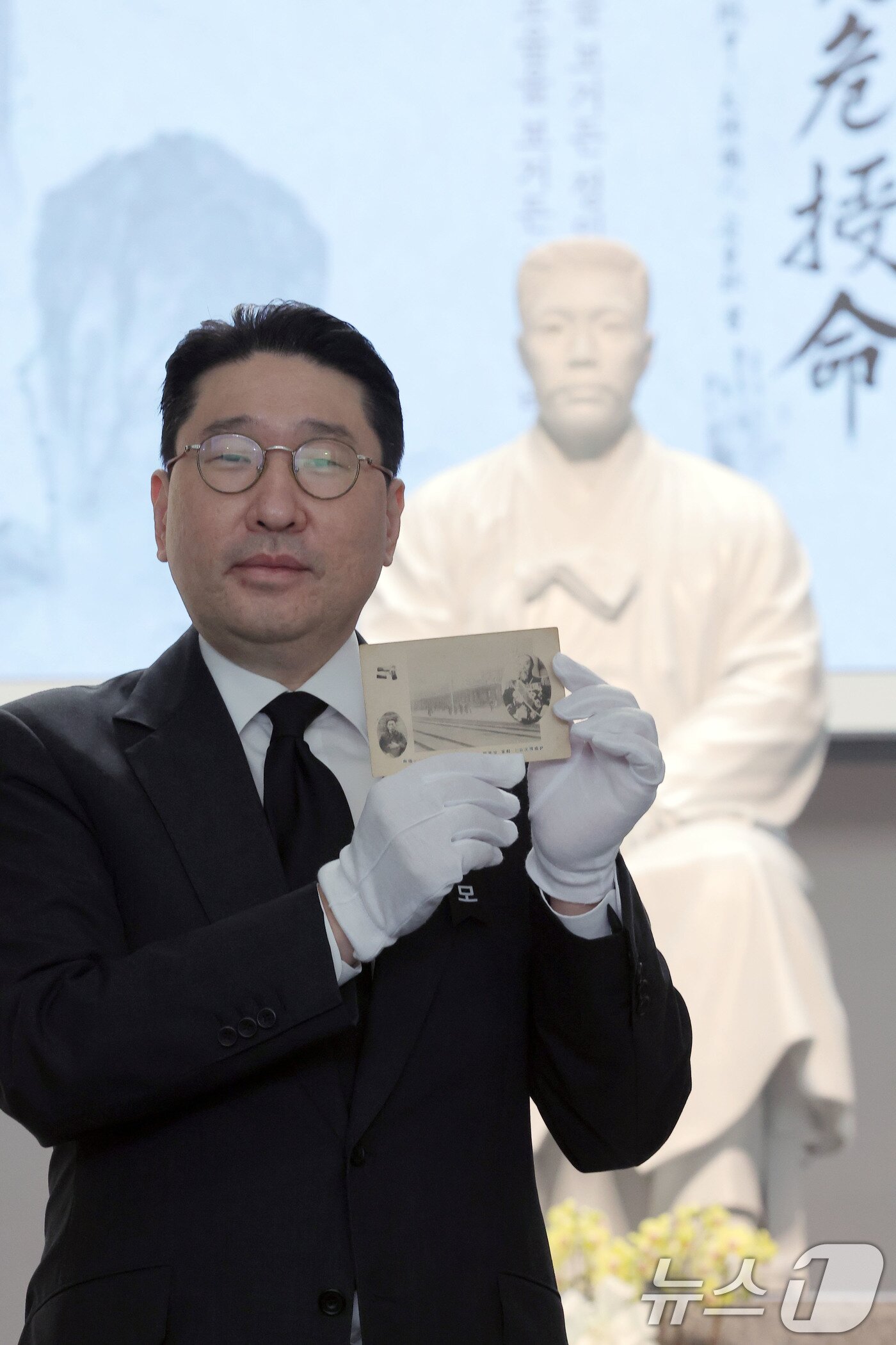 본문 이미지 - 이상현 안중근의사숭모회 이사&#40;태인 대표&#41;가 26일 오전 서울 중구 남산 안중근의사기념관에서 안중근 의사 순국 115주기 기념일을 맞아 안중근 의사와 이토히로부미가 한 화면에 담긴 엽서를 공개하고 있다.  2025.3.26/뉴스1 ⓒ News1 박정호 기자