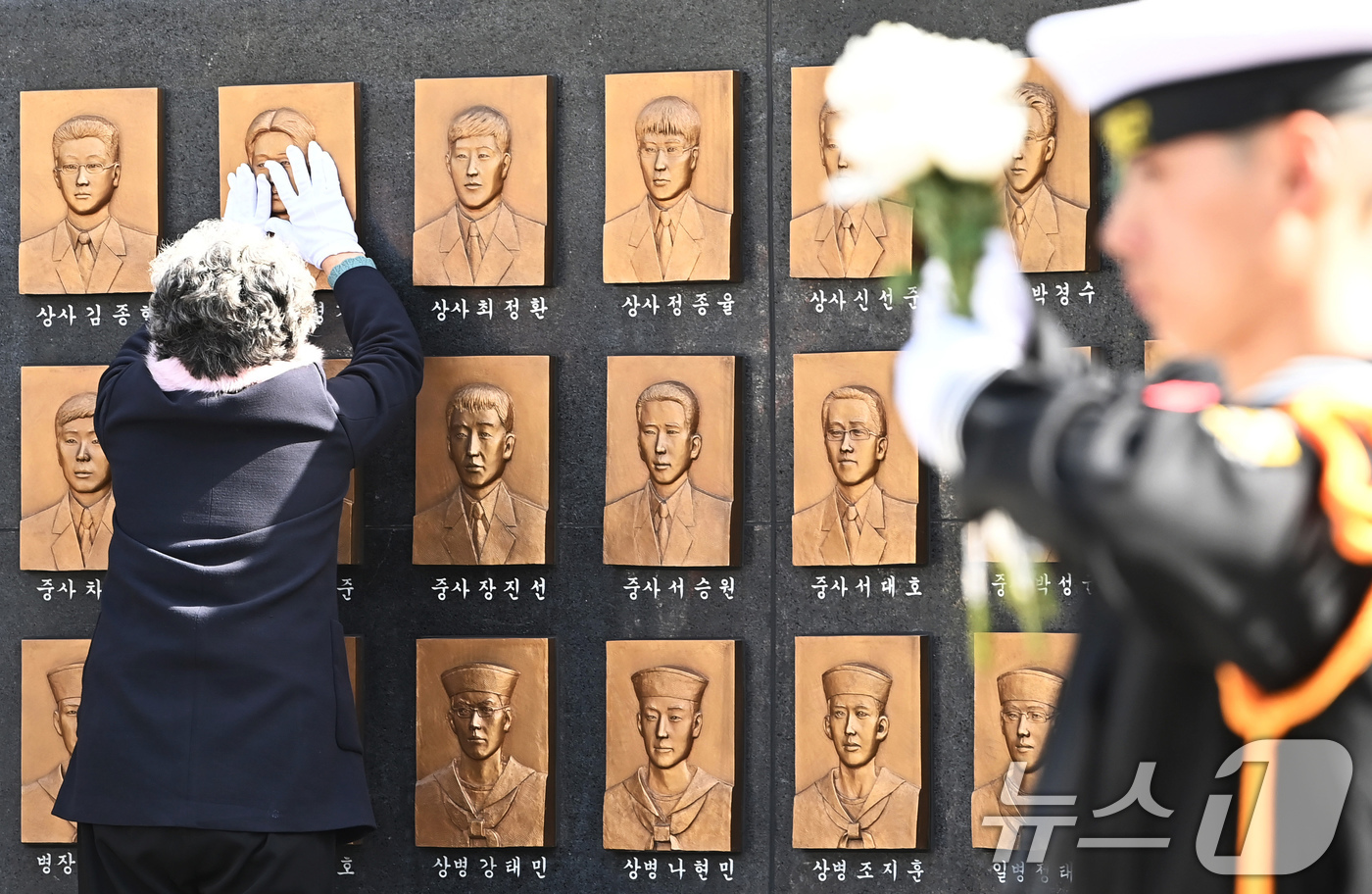 (평택=뉴스1) 장수영 기자 = 26일 경기도 평택시 해군 제2함대사령부에서 열린 제15주기 천안함 46용사 추모식에서 故 민평기 상사의 어머니가 추모비에 새겨진 아들의 얼굴을 만 …