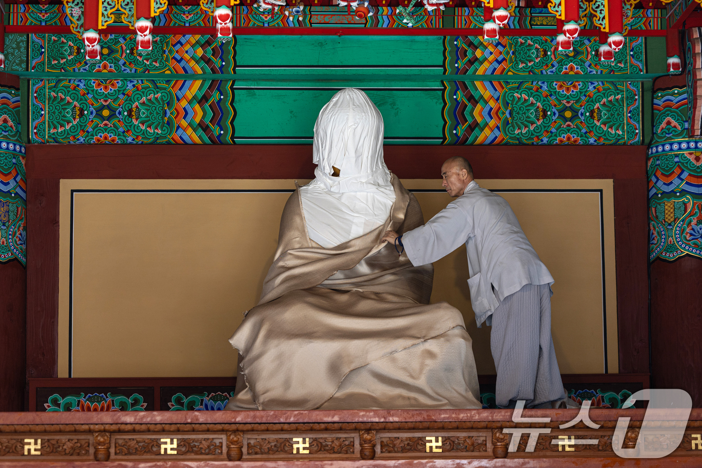 (안동=뉴스1) 이승배 기자 = 26일 경북 의성군 고운사 대웅전에서 스님이 불상에 씌운 방염포를 벗기고 있다.이번 경북 의성 산불로 국가지정 문화유산 보물로 지정된 고운사 가운루 …