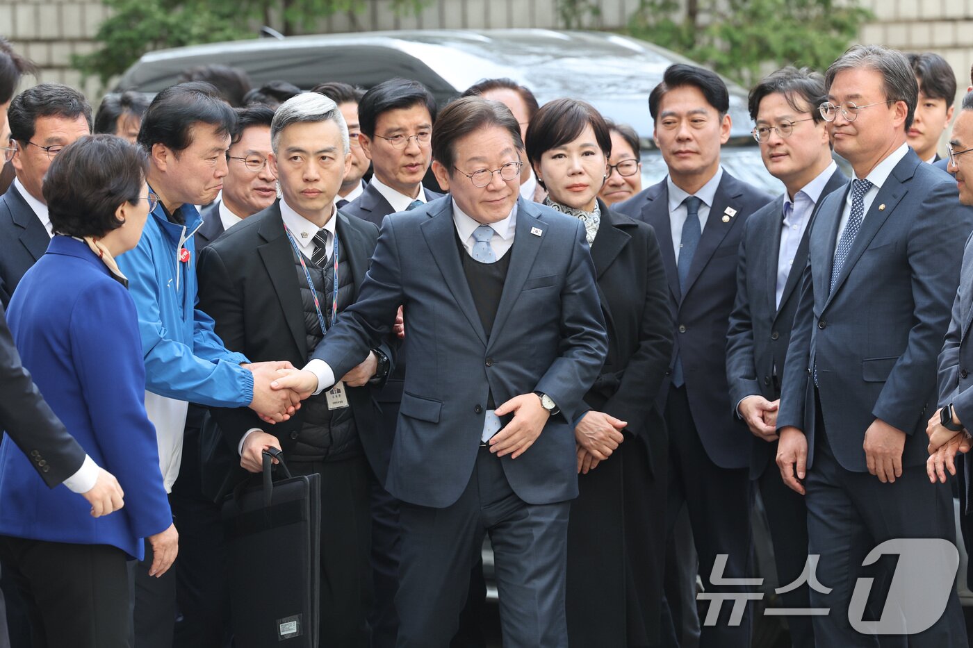 본문 이미지 - 더불어민주당 이재명 대표가 26일 서울중앙지법에서 열린 공직선거법 위반 사건 항소심 선고에 출석하며 의원들과 인사하고 있다. 2025.3.26/뉴스1 ⓒ News1 사진공동취재단