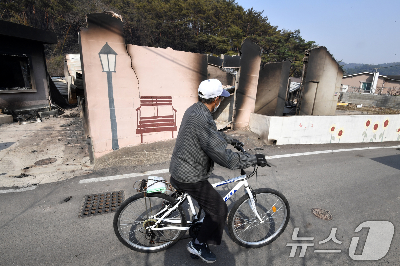 (영덕=뉴스1) 최창호 기자 = 지난 22일 경북 의성군에서 시작된 산불이 강풍을 타고 영덕군까지 확산된 26일 오후 한 주민이 불에 탄 집을 쳐다보고 있다. 2025.3.26/뉴 …