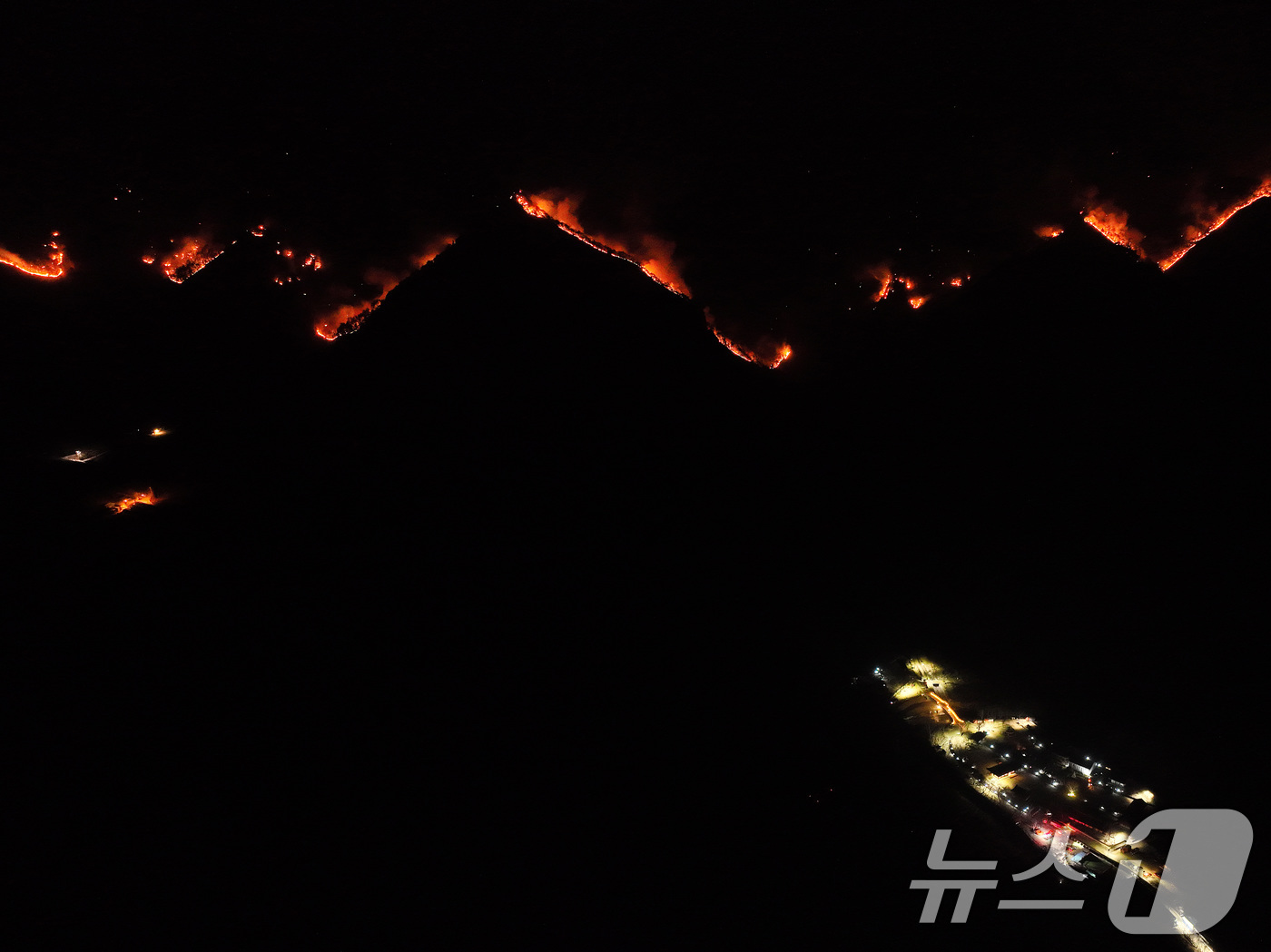 (청송=뉴스1) 공정식 기자 = 26일 오후 어둠이 내린 경북 청송군 주왕산면 상의리 주왕산국립공원에 산불이 번지고 있다.산불이 번진 주왕산 아래 대전사 사찰이 있다.2025.3. …