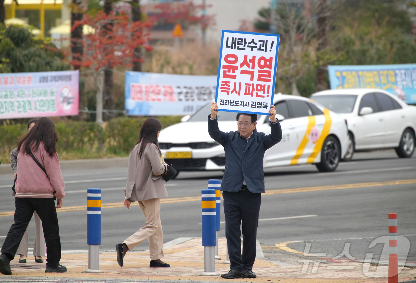 (무안=뉴스1) 전원 기자 = 김영록 전라남도지사가 27일 오전 무안군 삼향읍 농협 사거리 앞에서 출근길 차량과 시민들을 향해 윤석열 대통령 탄핵을 촉구하는 1인 시위를 하고 있다 …