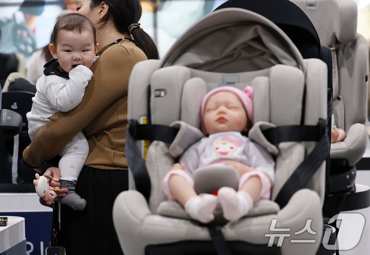 본문 이미지 - 27일 서울 강서구 코엑스 마곡에서 열린 마이비 마곡 베이비페어&유아교육전을 찾은 한 아이가 엄마와 함께 카시트 등 육아용품을 살펴보고 있다.  2025.3.27/뉴스1 ⓒ News1 박세연 기자