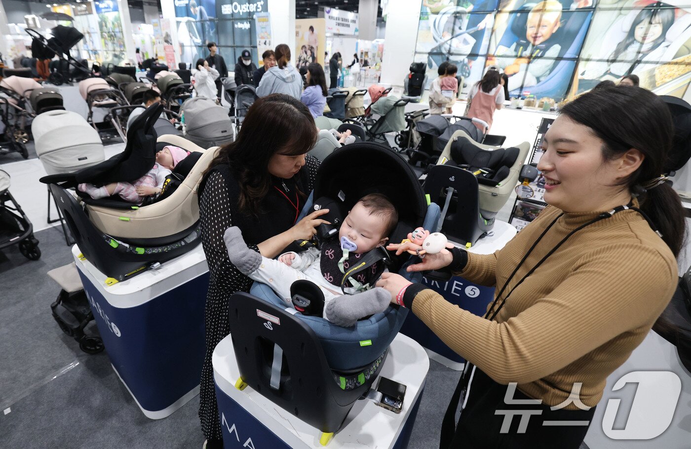 본문 이미지 - 27일 서울 강서구 코엑스 마곡에서 열린 마이비 마곡 베이비페어&유아교육전을 찾은 관람객이 카시트 등 육아용품을 살펴보고 있다. 2025.3.27/뉴스1 ⓒ News1 박세연 기자