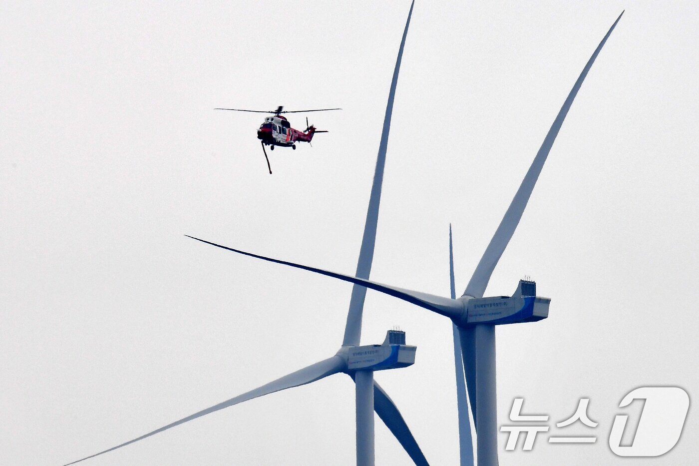 본문 이미지 - 지난해 3월27일 오후 경북 영덕군에서 산불 진화에 나선 경북소방본부 항공단 헬기가 영덕풍력발전기 주변을 날고 있다. ⓒ 뉴스1 최창호 기자