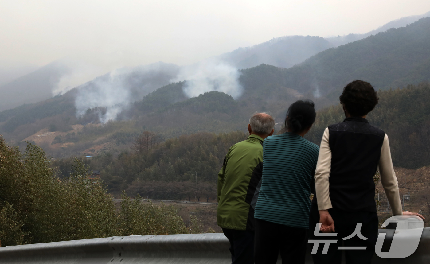 (산청=뉴스1) 윤일지 기자 = 경남 산청·하동 산불 일주일째인 27일 오후 주민들이 지리산과 인접한 산청군 시천면 동당마을 위로 피어오르는 산불 연기를 지켜보고 있다.산청에는 오 …