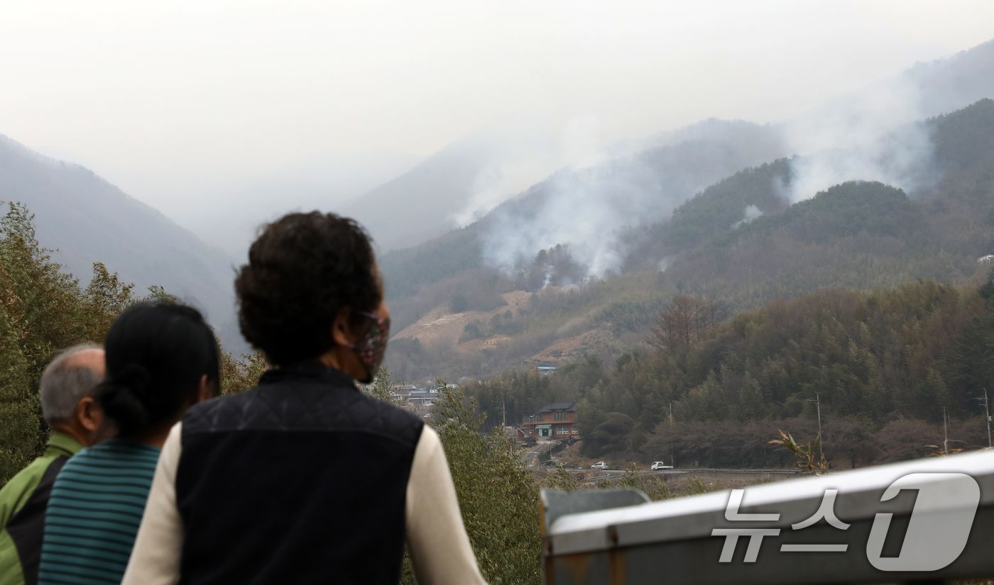 (산청=뉴스1) 윤일지 기자 = 경남 산청·하동 산불 일주일째인 27일 오후 주민들이 지리산과 인접한 산청군 시천면 동당마을 위로 피어오르는 산불 연기를 지켜보고 있다.산청에는 오 …