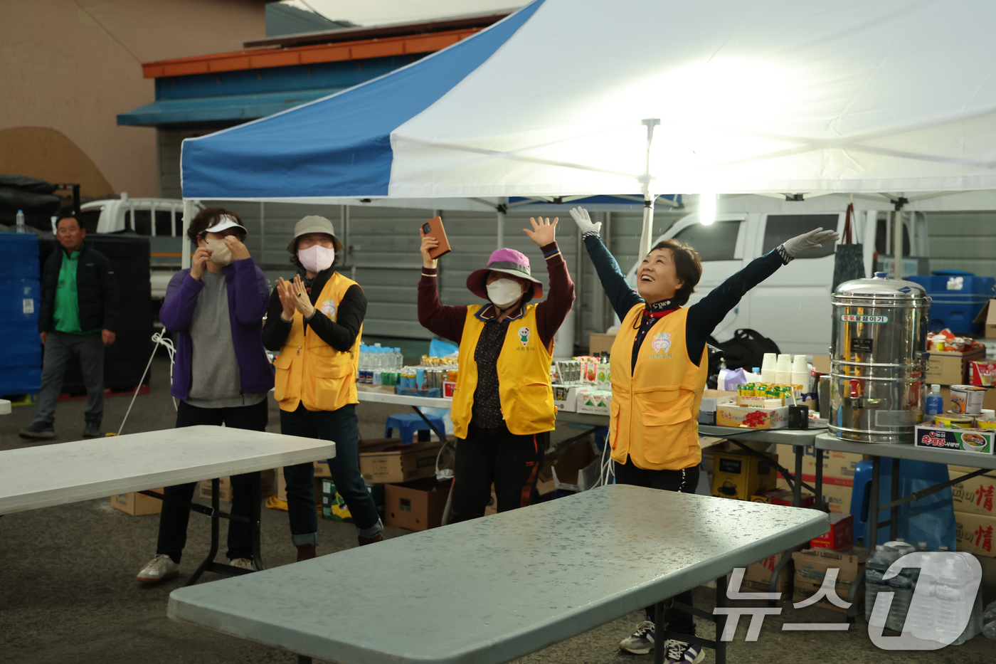 (산청=뉴스1) 윤일지 기자 = 경남 산청·하동 산불 일주일째인 27일 오후 산청군 시천면 곶감유통센터에 마련된 산불현장통합지휘본부에서 자원봉사자들이 기다리던 단비에 환호하고 있다 …