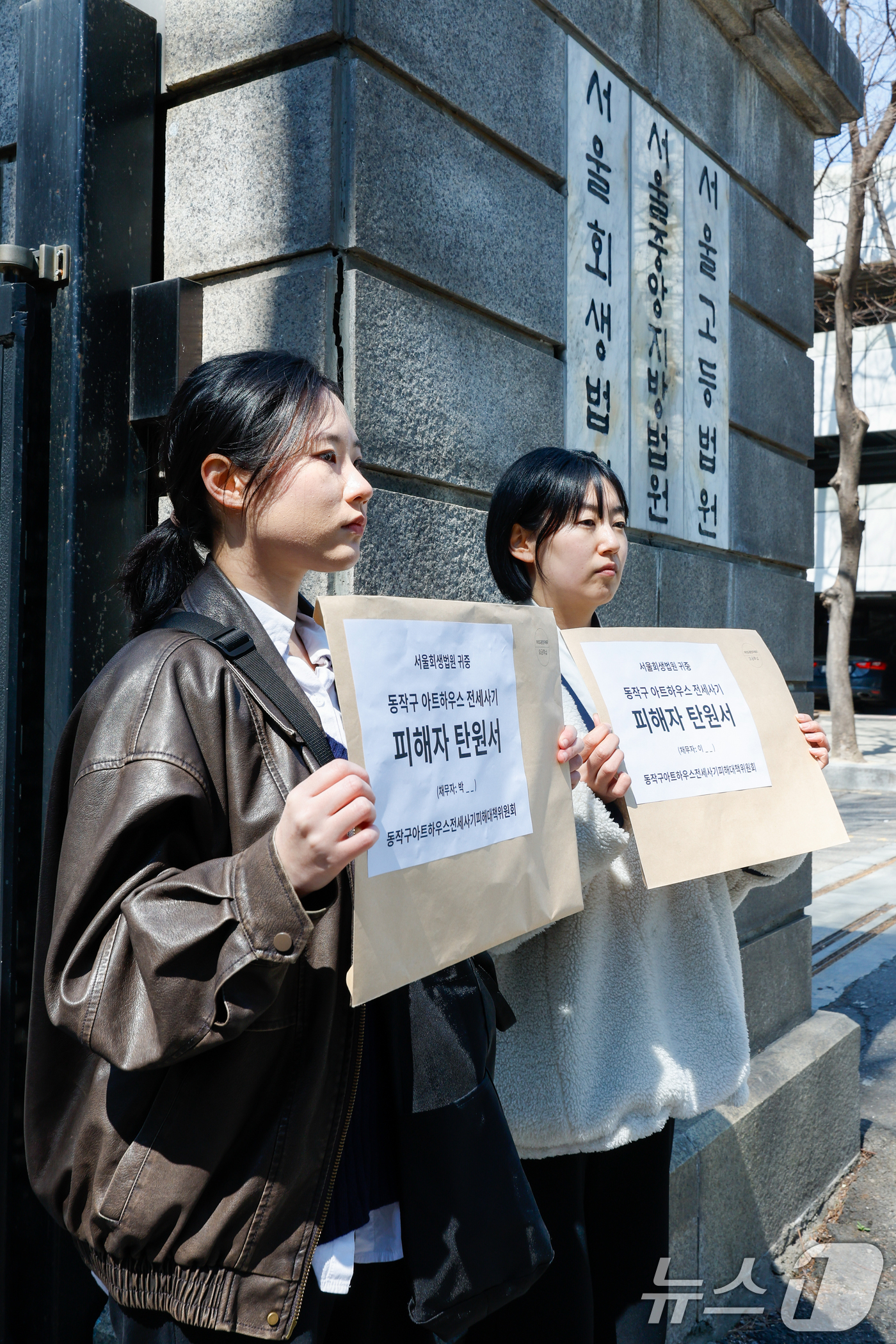 (서울=뉴스1) 안은나 기자 = 강다영 동작구 아트하우스 전세사기 피해대책위원장(오른쪽)과 피해자들이 28일 서초구 서울회생법원 앞에서 전세사기 피해자들의 전세보증금 채권 비면책 …