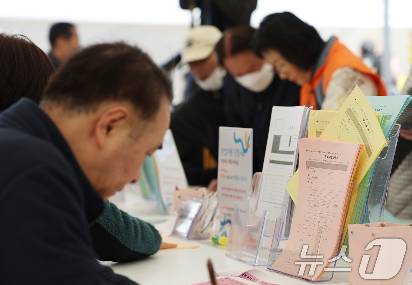 (수원=뉴스1) 김영운 기자 = 28일 오후 경기 수원시 팔달구 화성행궁광장에서 열린 '2025년 제17회 노인일자리 채용 한마당'에서 60세 이상 고령 구직자들이 이력서를 작성하 …