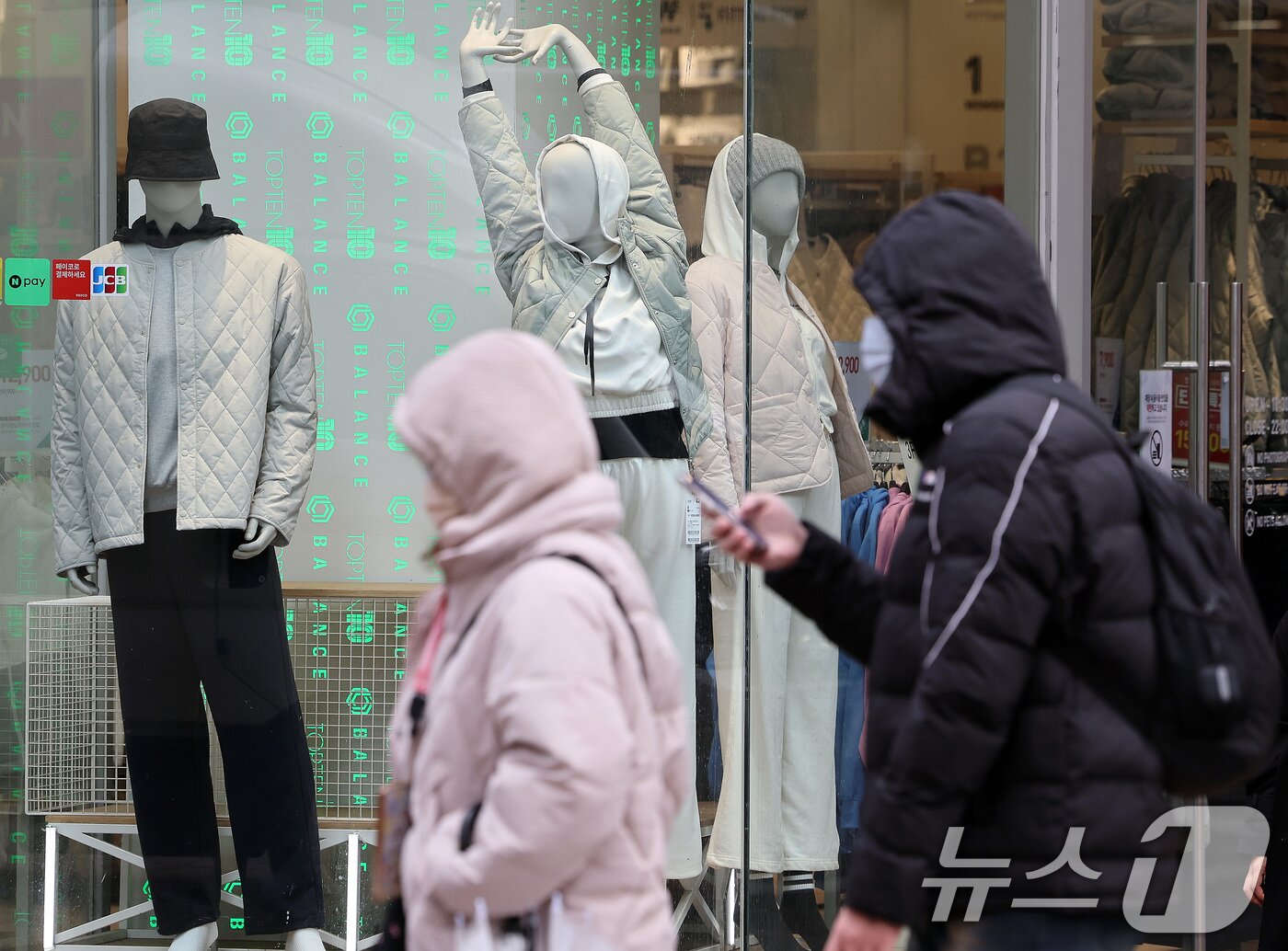 본문 이미지 - 삼일절 연휴기간 전국적으로 눈·비가 내리며 짧은 꽃샘추위가 찾아온 3일 서울 명동거리에서 두터운 옷을 입은 관광객이 봄옷이 걸린 쇼윈도를 지나가고 있다. 2025.3.3/뉴스1 ⓒ News1 이동해 기자