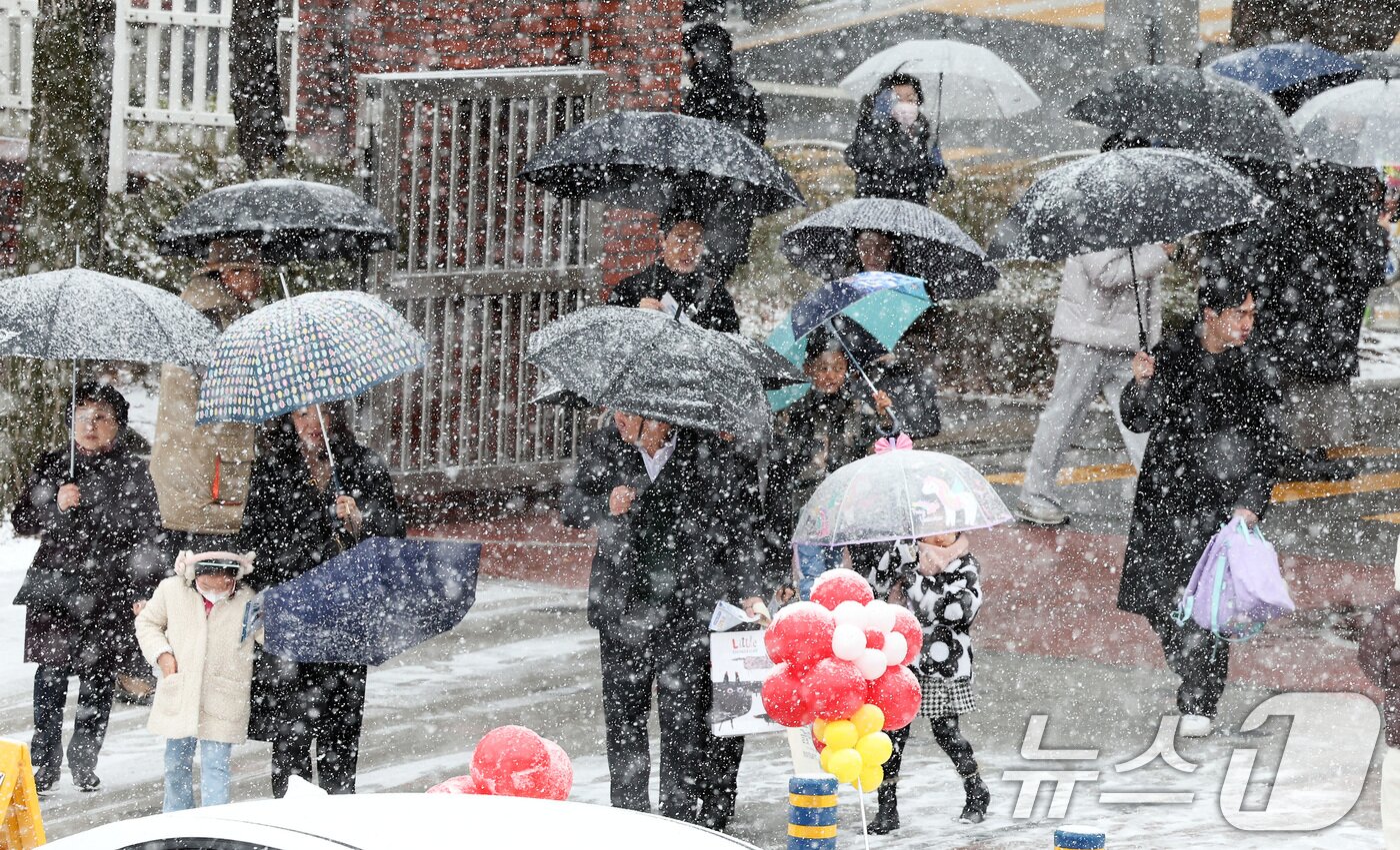 본문 이미지 - 4일 오전 서울 마포구 아현초등학교에서 열린 2025학년도 입학식에 학부모와 1학년 신입생들이 쏟아지는 눈을 맞으며 이동하고 있다. 2025.3.4/뉴스1 ⓒ News1 이동해 기자