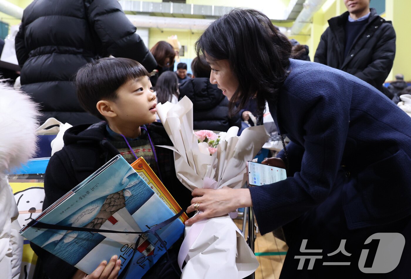 본문 이미지 - 4일 오전 서울 마포구 아현초등학교에서 열린 2025학년도 입학식에서 학부모들이 1학년 자녀에게 책 선물을 하고 있다. 2025.3.4/뉴스1 ⓒ News1 이동해 기자