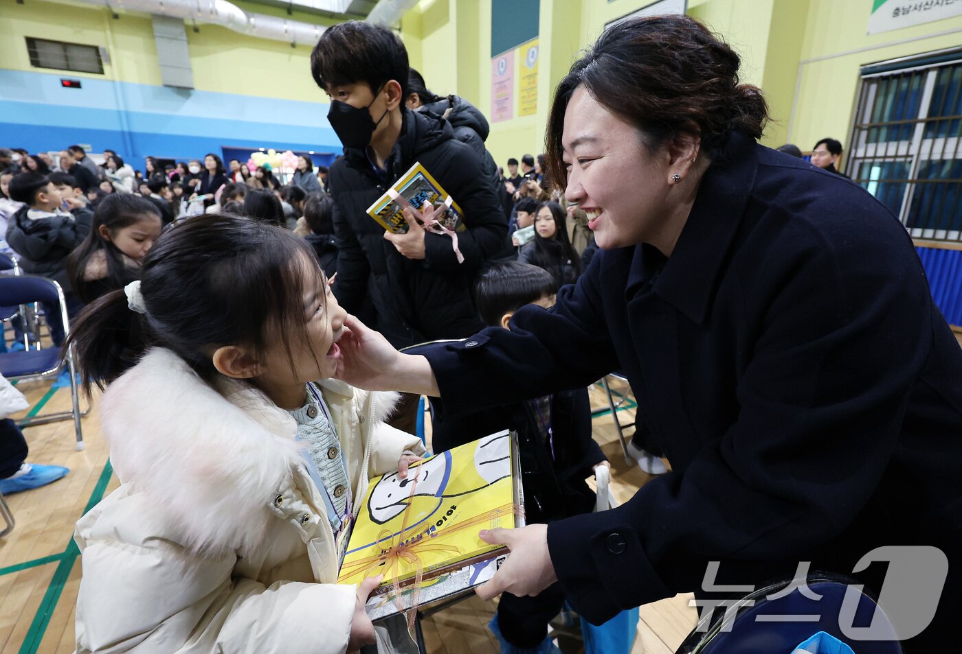 본문 이미지 - 4일 오전 서울 마포구 아현초등학교에서 열린 2025학년도 입학식에서 학부모들이 1학년 자녀에게 책 선물을 하고 있다. 2025.3.4/뉴스1 ⓒ News1 이동해 기자