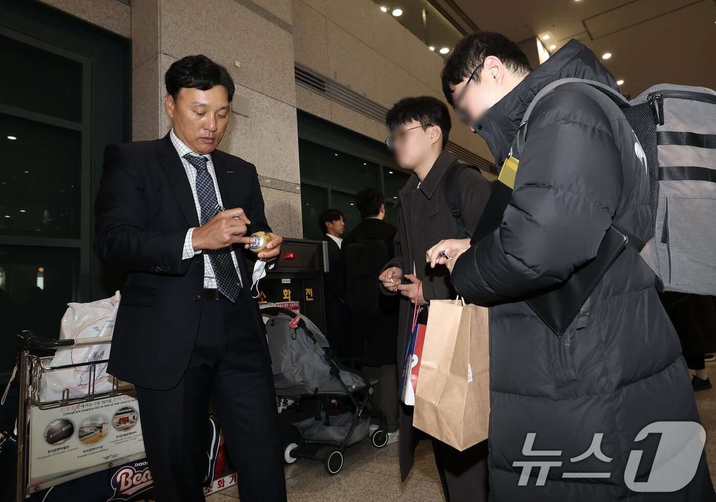 본문 이미지 - 프로야구 두산 베어스 이승엽 감독이 36일 간의 스프링캠프 전지훈련을 마치고 4일 오후 인천국제공항을 통해 귀국해 팬들에게 사인을 해주고 있다. 2025.3.4/뉴스1 ⓒ News1 오대일 기자