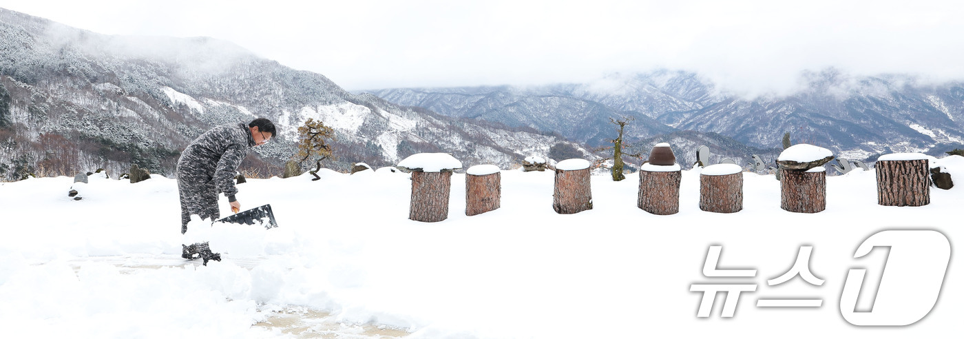 (서울=뉴스1) = 절기상 경칩이자 포근한 날씨를 보인 5일 경남 함양군 마천면 한 주민이 지리산을 배경으로 앞마당에 쌓인 눈을 치우고 있다. (함양군 김용만 제공. 재판매 및 D …
