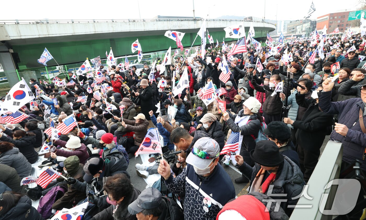 본문 이미지 - 법원이 내란 수괴 혐의로 구속기소된 윤석열 대통령의 구속 취소를 인용한 7일 서울 용산구 한남동 대통령 관저 인근에 윤대통령 지지자들이 피켓을 들고 구호를 외치고 있다. 2025.3.7/뉴스1 ⓒ News1 권현진 기자