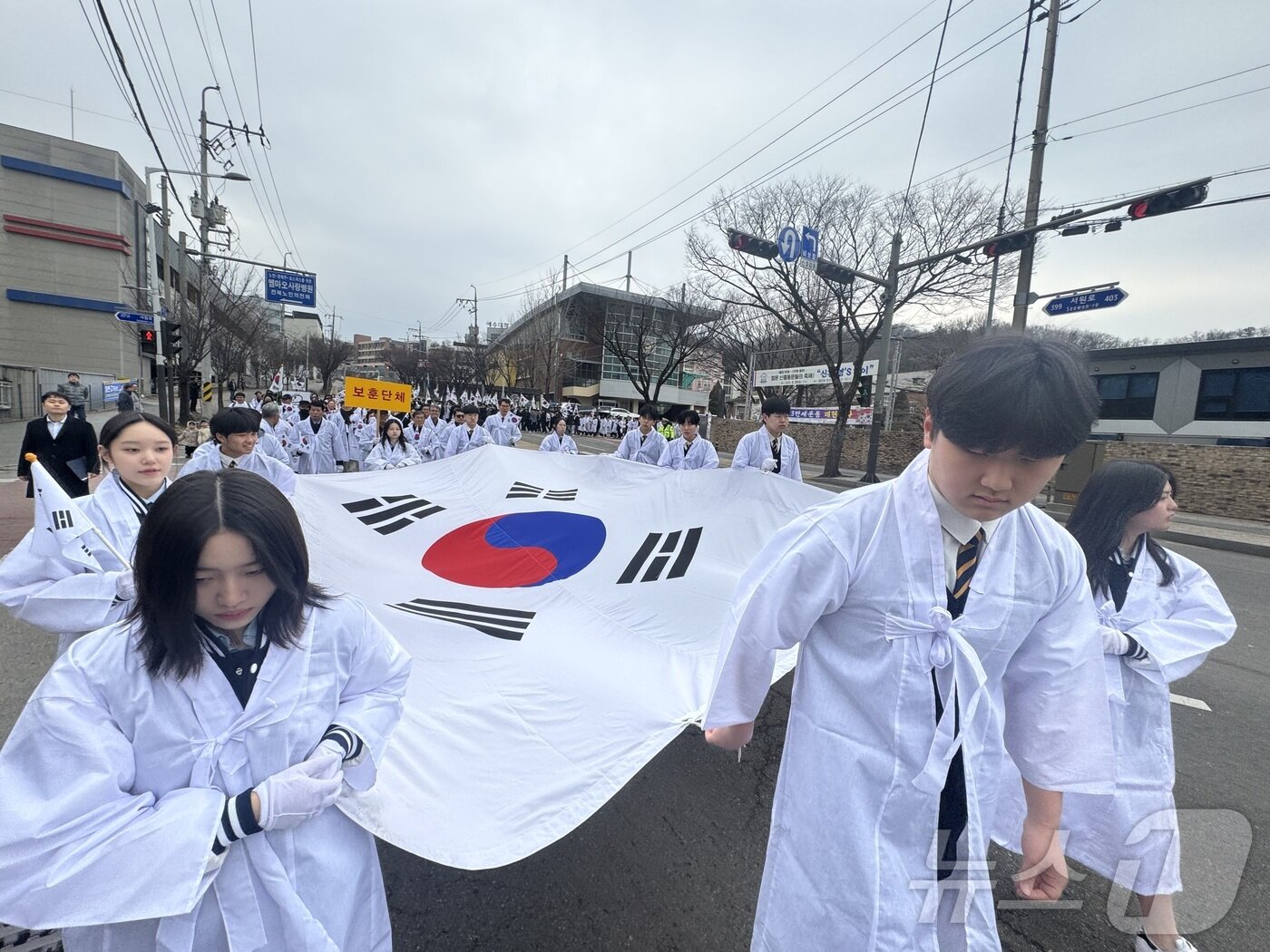 본문 이미지 - 8일 오전 전북 전주시 완산구 신흥고등학교에서 '전주 3·13 만세운동' 재현행사가 열린 가운데 신흥고학생들과 기전여고 학생들이 태극기를 들고 행진하고 있다. 2025.3.8/뉴스1 ⓒ News1 장수인 기자