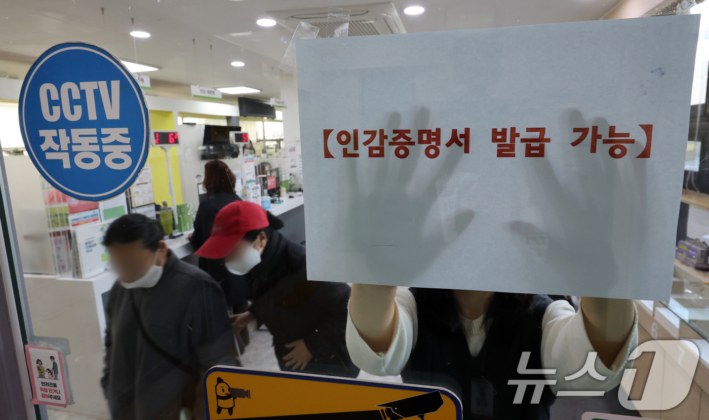 (서울=뉴스1) 이동해 기자 = 1일 서울 시내의 한 동사무소에서 관계자가 인감증명서 발급 가능 안내문을 붙이고 있다.이날 오전 정부 행정 전상망 장애로 주민등록 인감과 등·초본 …