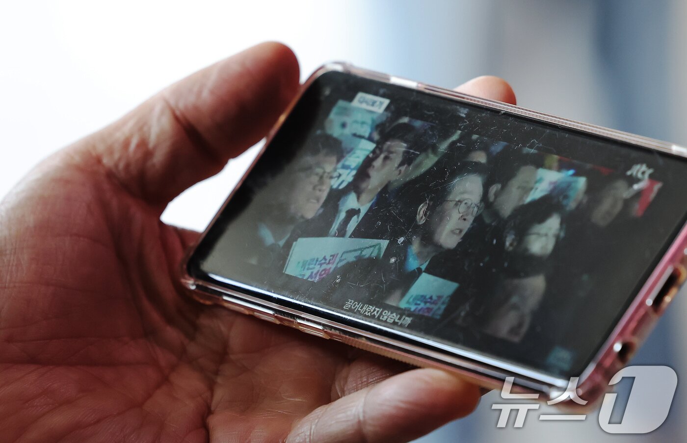 본문 이미지 - 10일 오전 서울 중구 서울역을 찾은 시민이 스마트폰을 통해 이재명 전 더불어민주당 대표의 대통령 선거 출마 선언 영상을 바라보고 있다. 2025.4.10/뉴스1 ⓒ News1 장수영 기자