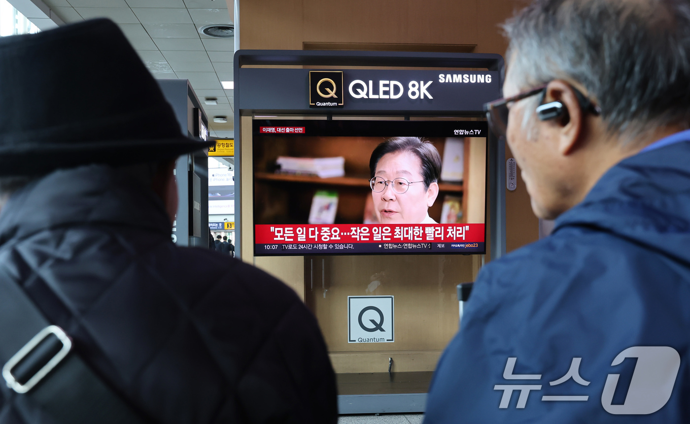 (서울=뉴스1) 장수영 기자 = 10일 오전 서울 중구 서울역을 찾은 시민들이 TV를 통해 나오는 이재명 전 더불어민주당 대표의 대통령 선거 출마 선언 영상을 바라보고 있다. 20 …