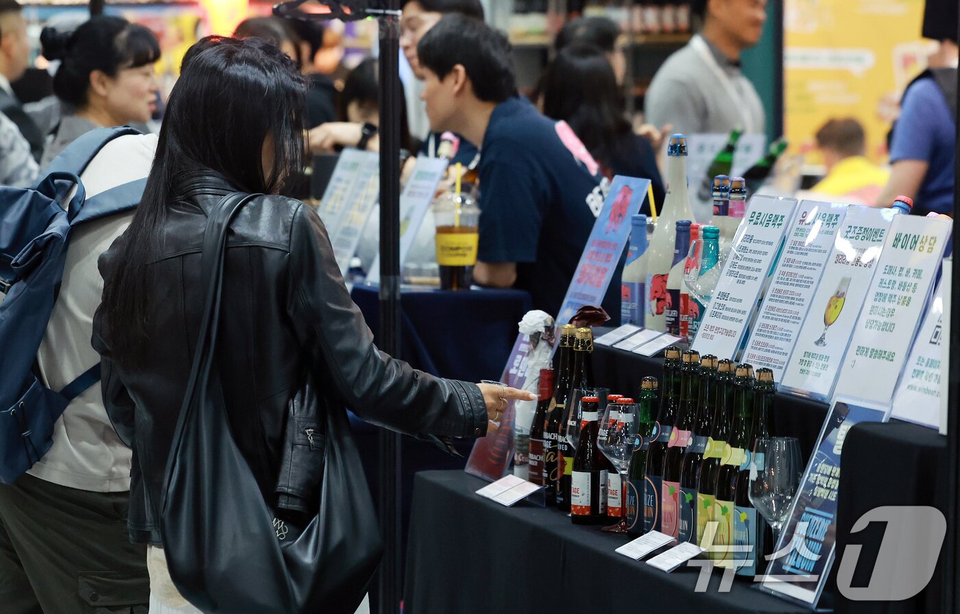 본문 이미지 - 10일 서울 강남구 코엑스에서 열린 대한민국 맥주박람회 및 드링크서울에서 참관객들이 다양한 수제맥주를 살펴보고 있다. 2025.4.10/뉴스1 ⓒ News1 김진환 기자