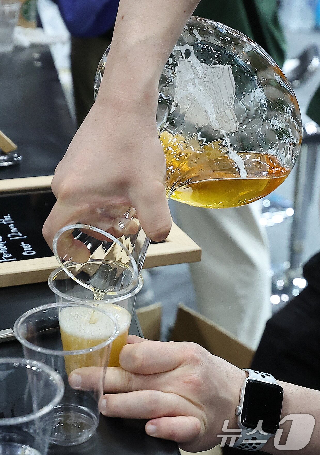 본문 이미지 - 10일 서울 강남구 코엑스에서 열린 대한민국 맥주박람회 및 드링크서울에서 부스 관계자가 수제맥주를 컵에 따르고 있다.  2025.4.10/뉴스1 ⓒ News1 김진환 기자