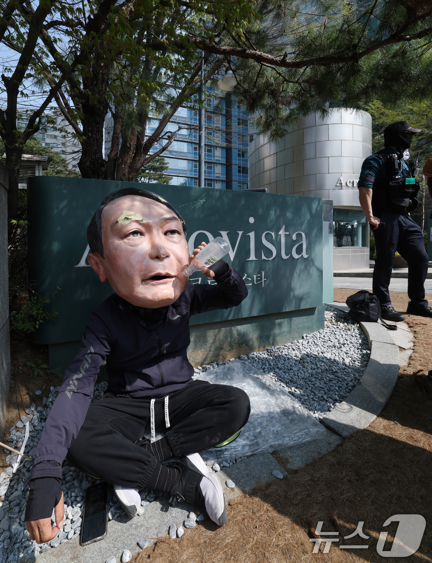 (서울=뉴스1) 박세연 기자 = 11일 윤석열 전 대통령 사저인 서울 서초구 아크로비스타 앞에 윤 전 대통령을 반대하는 한 시민이 윤 전 대통령 탈을 쓰고 앉아있다.윤 전 대통령은 …